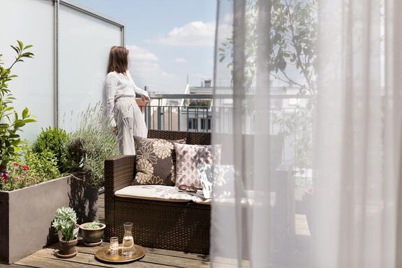 Frau auf Terrasse mit Ausblick
