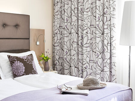 Room in our category economy with a double bed and lilac colours