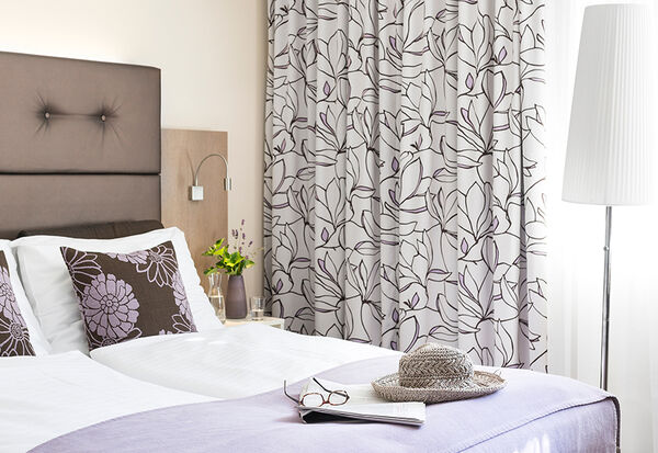 Room in our category economy with a double bed and lilac colours