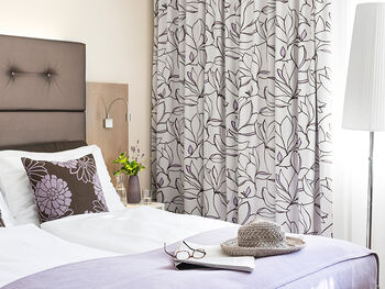 Room in our category economy with a double bed and lilac colours