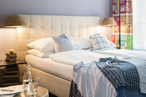 A bed with blue bedclothes in the boutique hotel Stadthalle in Vienna