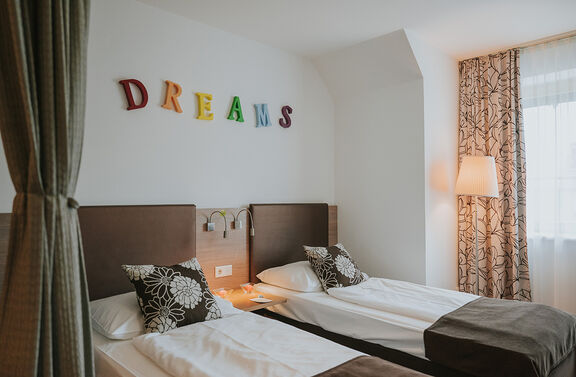 Gartenblick Doppelzimmer mit bunter Wandüberschrift "Dreams"