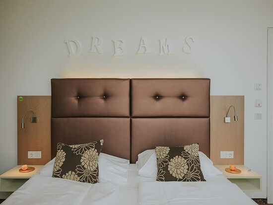 Barrierefreies Zimmer Bett frontal mit Dreams Überschrift an der Wand