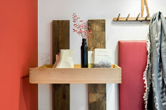 Ein Regal mit einer schwarzen Vase und zwei Büchern