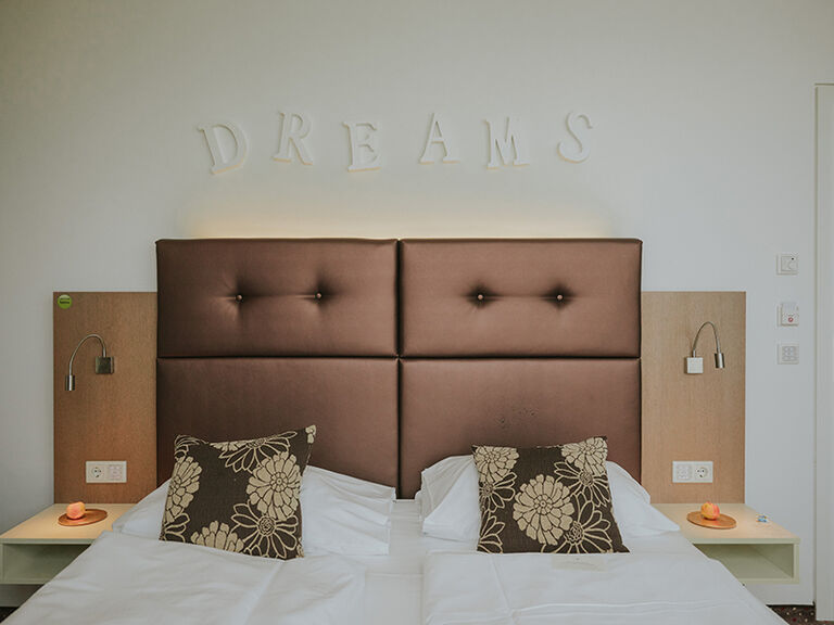 Barrierefreies Zimmer Bett frontal mit Dreams Überschrift an der Wand